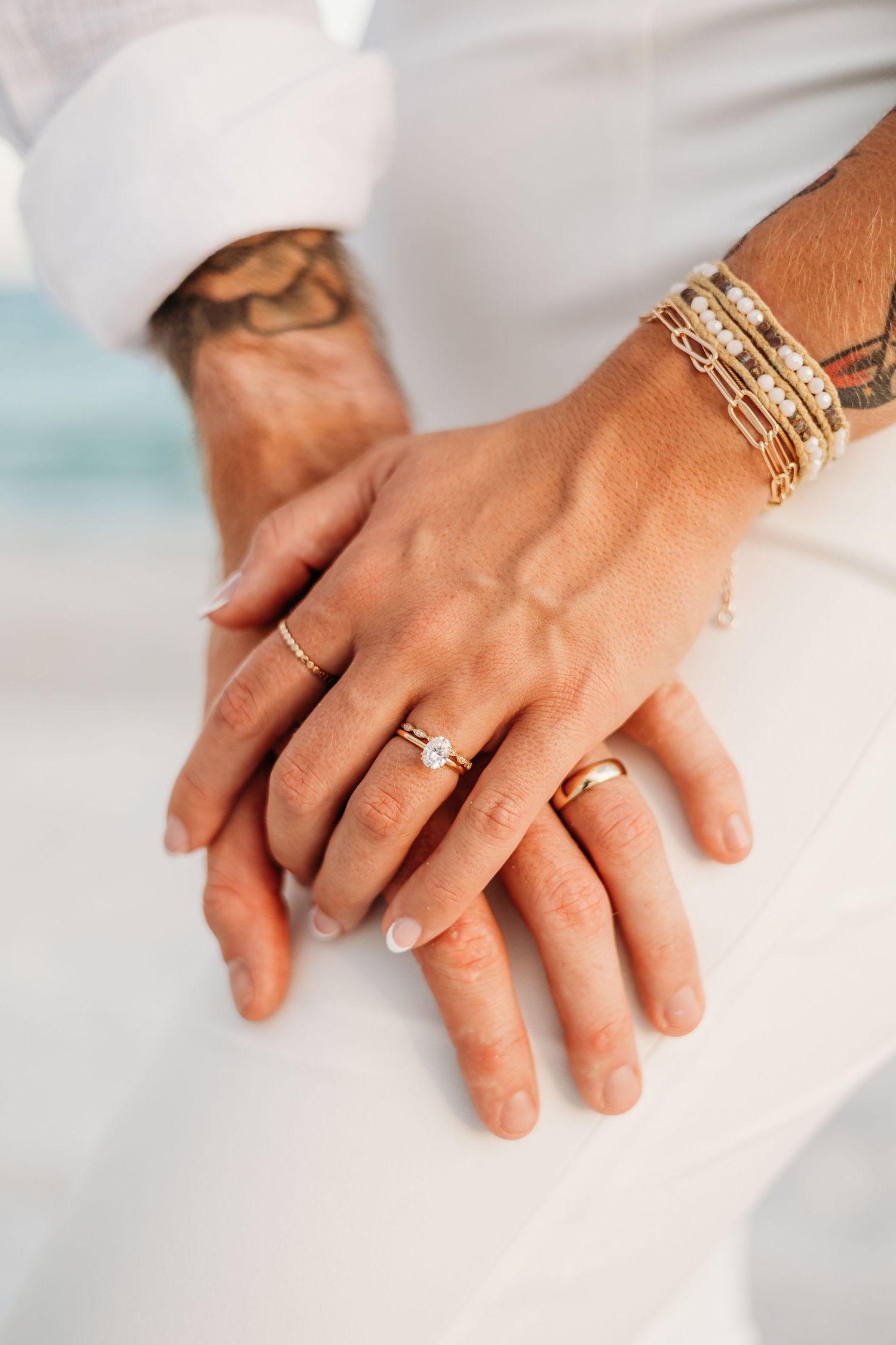 Close-up sequence of hands with gold bracelets and rings showing progressive stages of holding and touching.