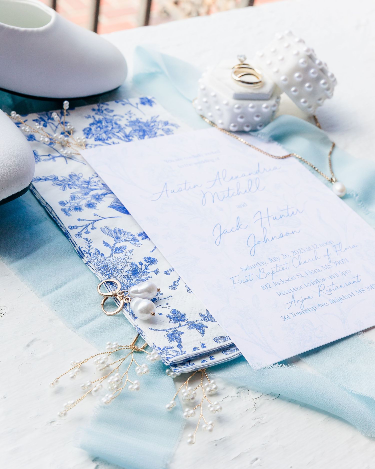 Elegant blue and white wedding invitations with floral details and soft styling.