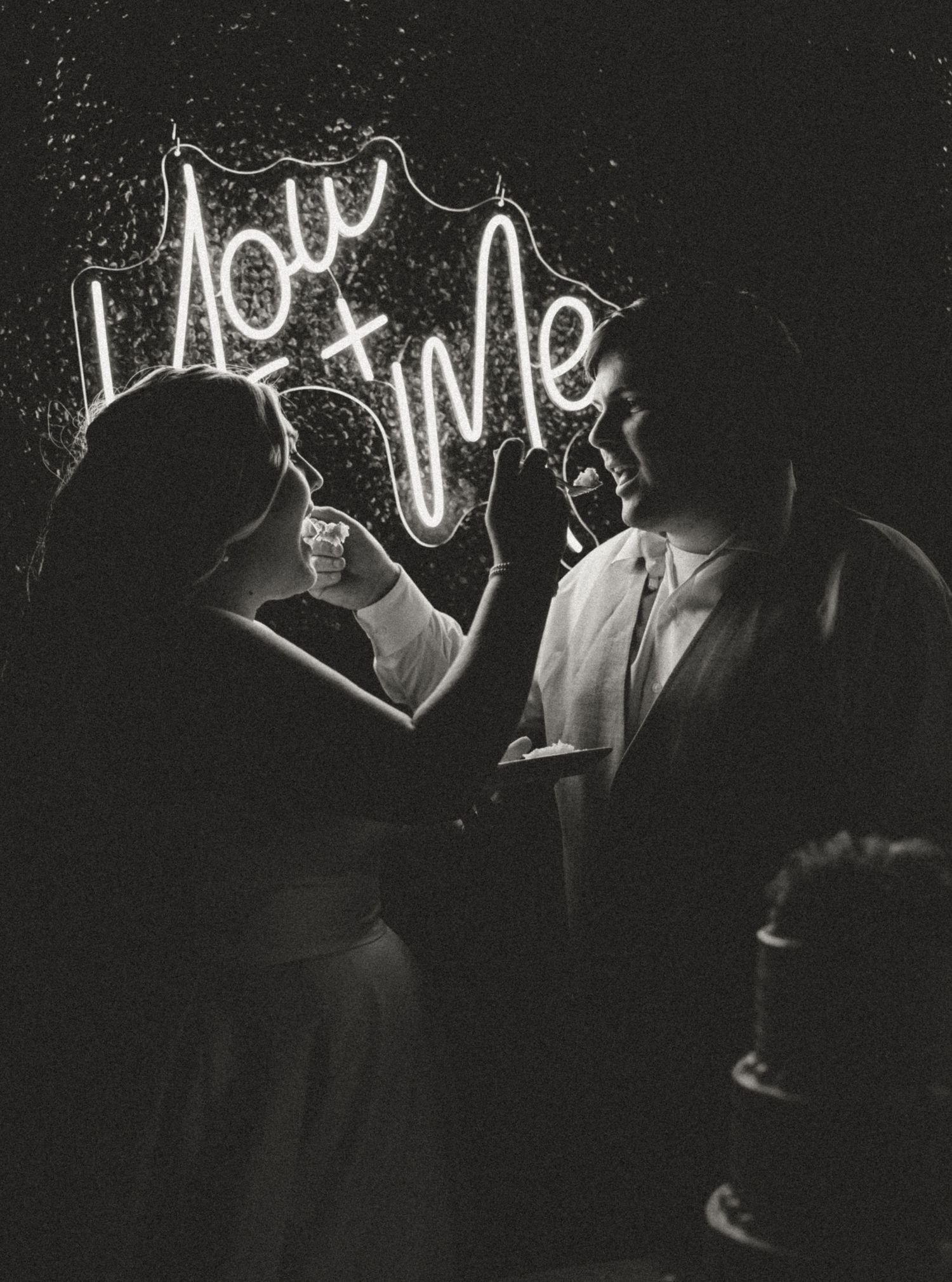 A vintage black and white photograph shows light painting spelling 'hot wine' in glowing script against a dark background.