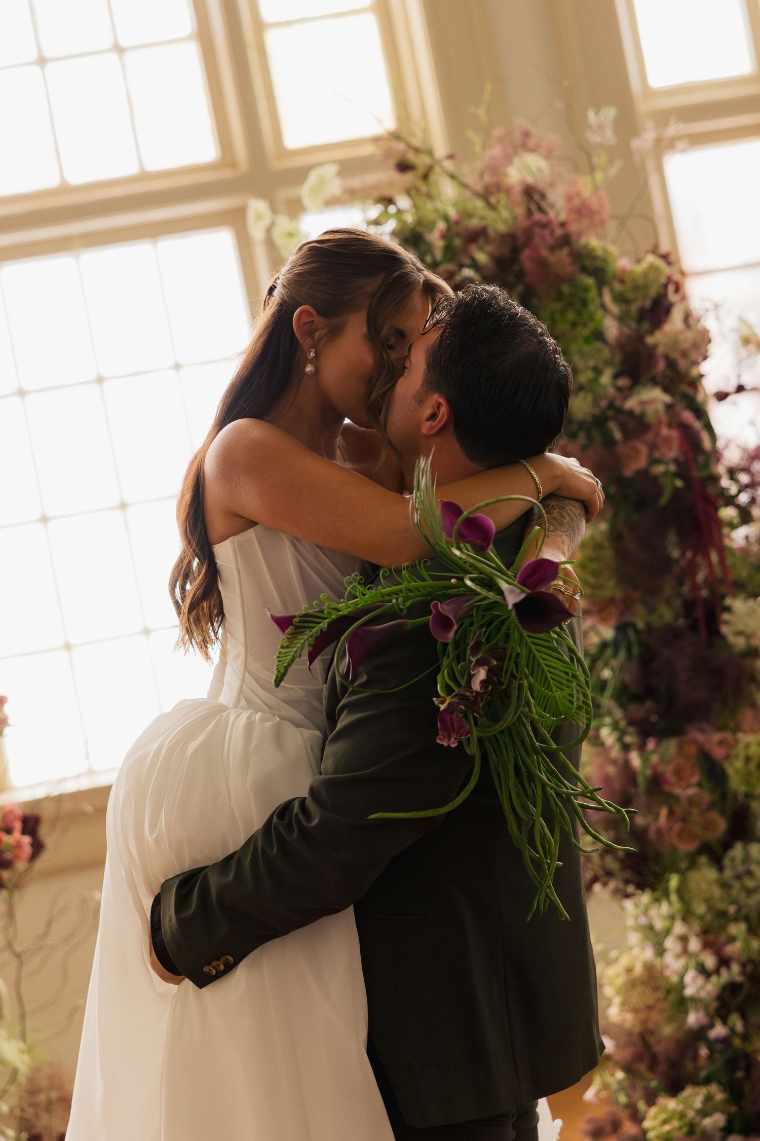 Close-up of a bride and groom, eyes closed and smiling as they lean in, capturing an intimate and joyful wedding day moment.
