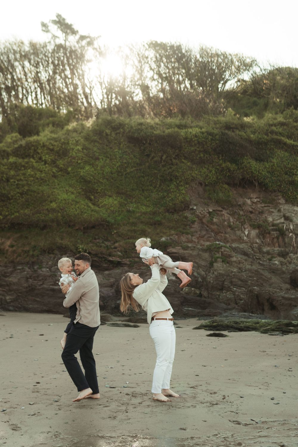 A playful sequence of photos showing a couple in casual attire dancing on a sandy beach next to rocky cliffs.