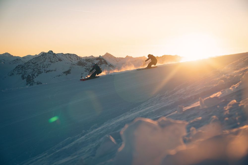 two person skiing down a mountain at sunrise.
Photographer: Urban Engel Perspectiva