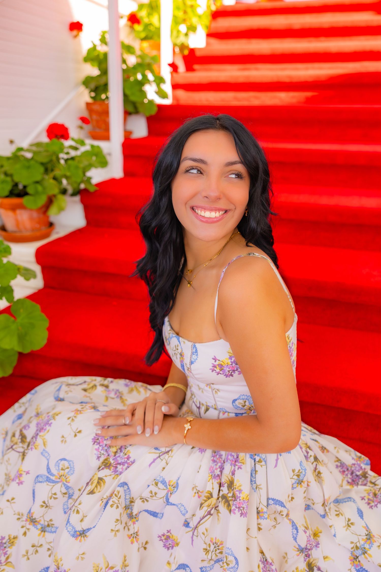 A floral sundress photographed against bright red stairs and green foliage. Katharine Rose Photography | Mackinac Island, MI | Saint Ignace,
