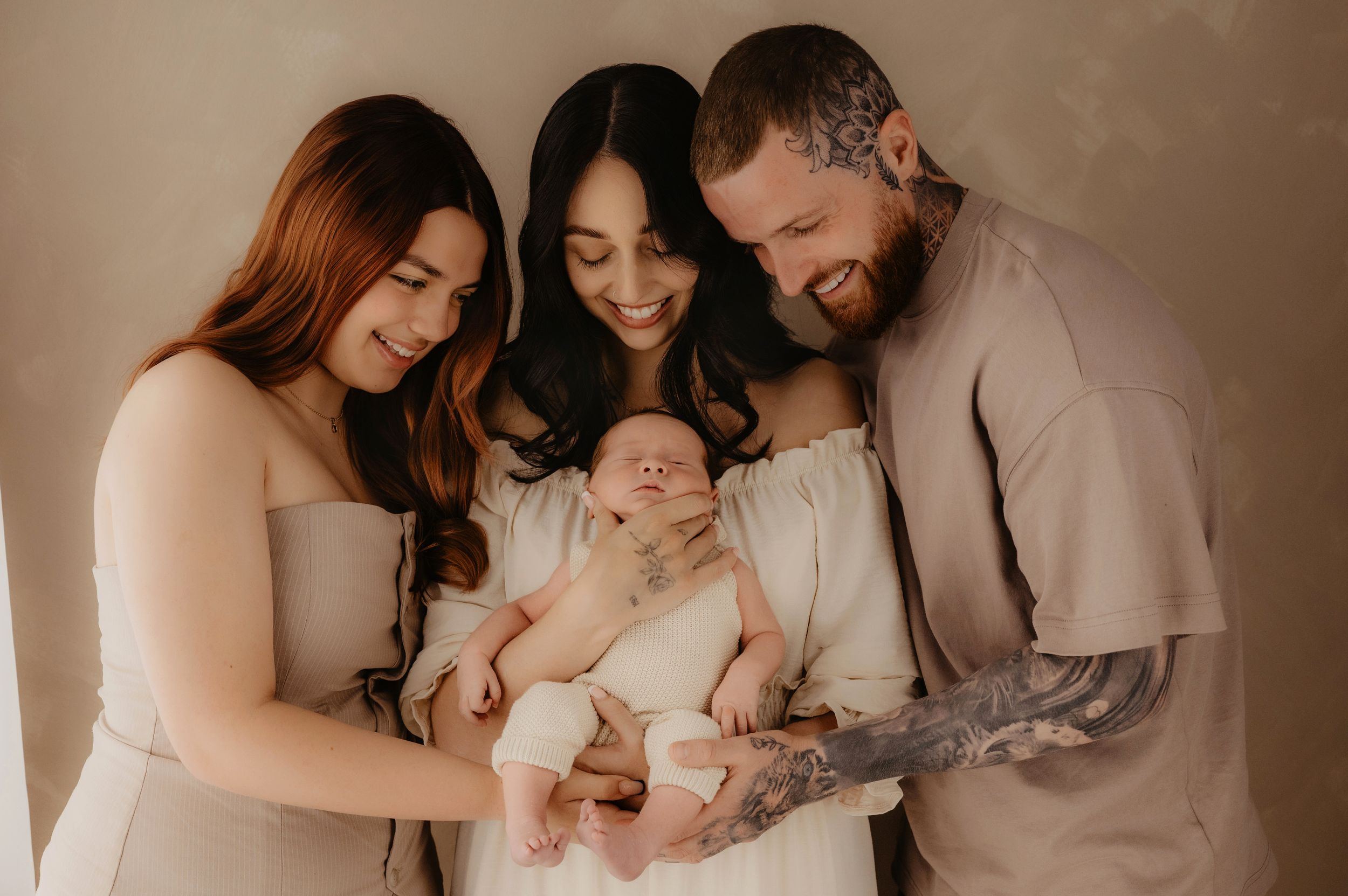Family portrait series with newborn baby in soft beige tones.