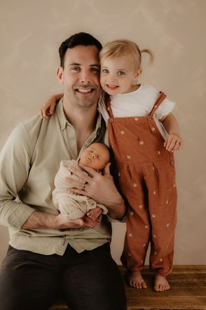 Modern family portrait series with newborn in earth-toned studio setting.