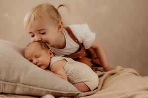Baby resting on soft textures in a gentle neutral environment.