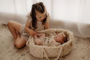 Artistic monochrome series showing tender newborn photography session setup.