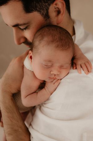 Intimate series of parent giving gentle kisses to sleeping newborn.