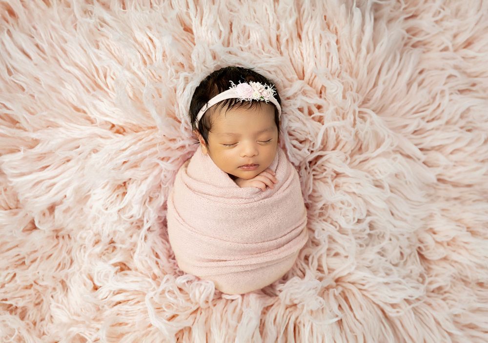 Five connected studio photographs of a sleeping newborn baby on soft pink fluffy textures.