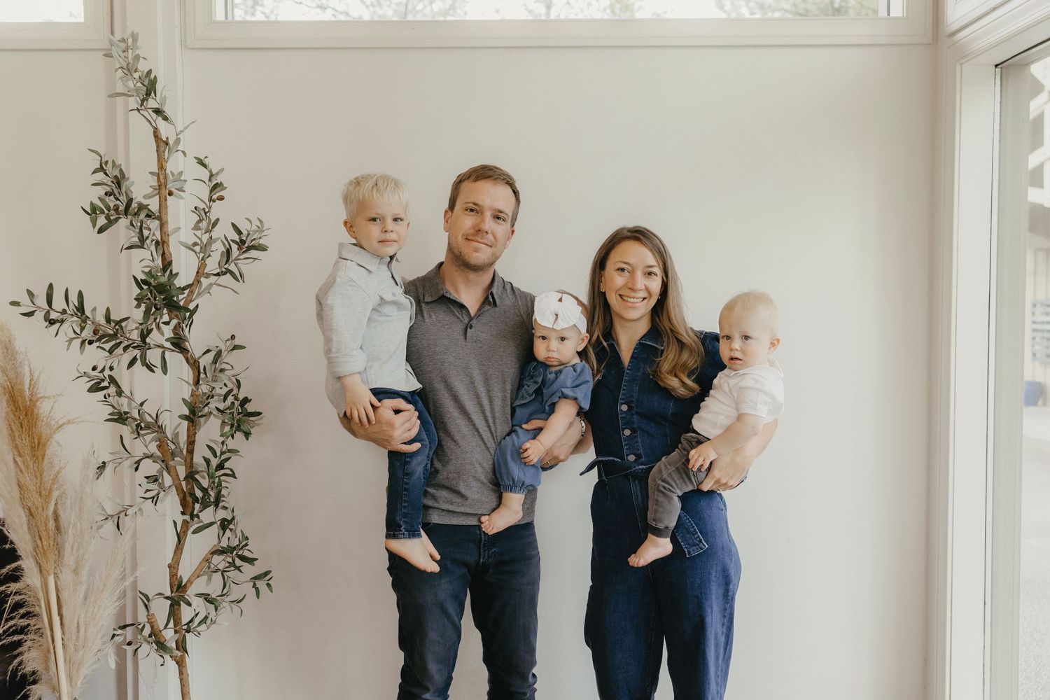 Family portrait in bright minimal interior with indoor plants.
