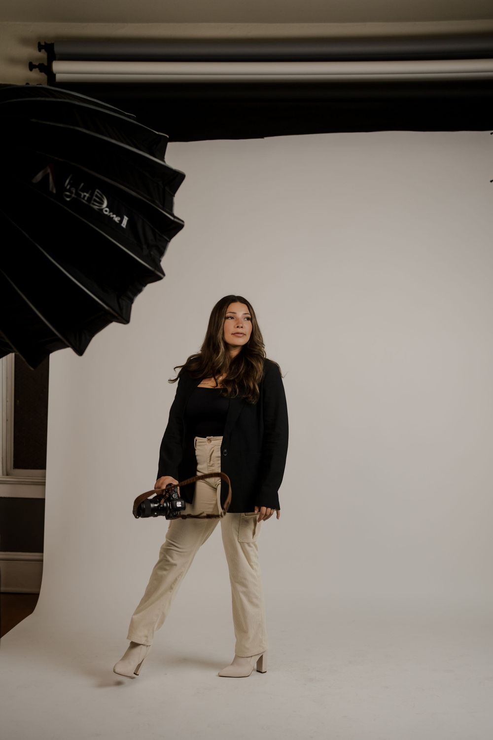 Woman in a black jacket standing in a photography studio