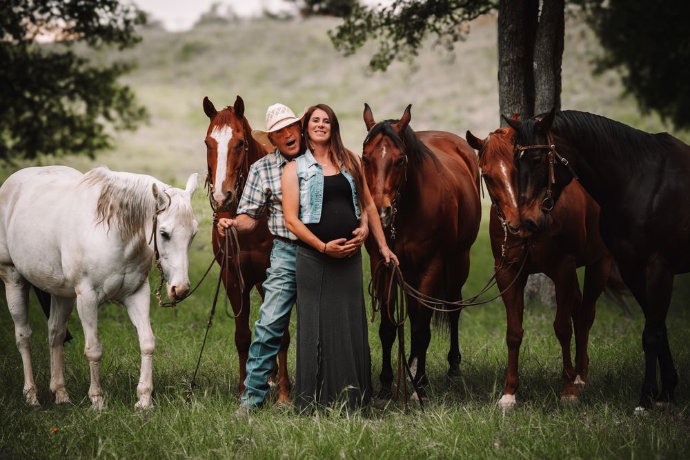 Couple posing with their horses during an equine maternity photography session near San Antonio, Texas