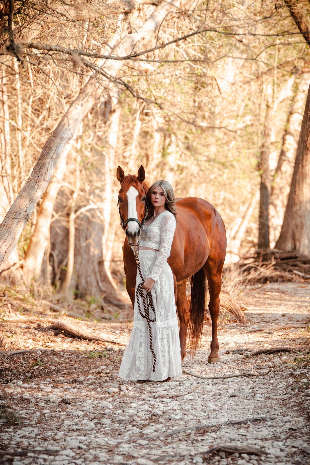 Woman standing with horse in the trees
Woman with her horse during an equine portrait session in Boerne, Texas
