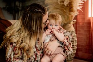 Tender moment captured during indoor lifestyle portrait session with natural window light.