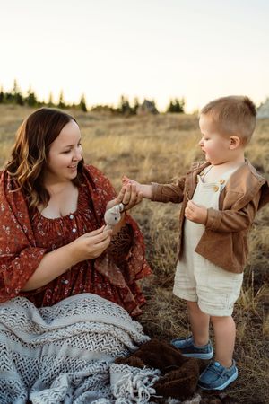 A series of candid outdoor photos showing tender moments between parent and child in a rustic field at sunset.