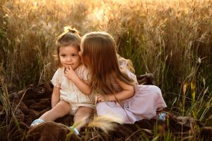 A loving scene in a sunlit meadow with tall grass and warm golden light at sunset.