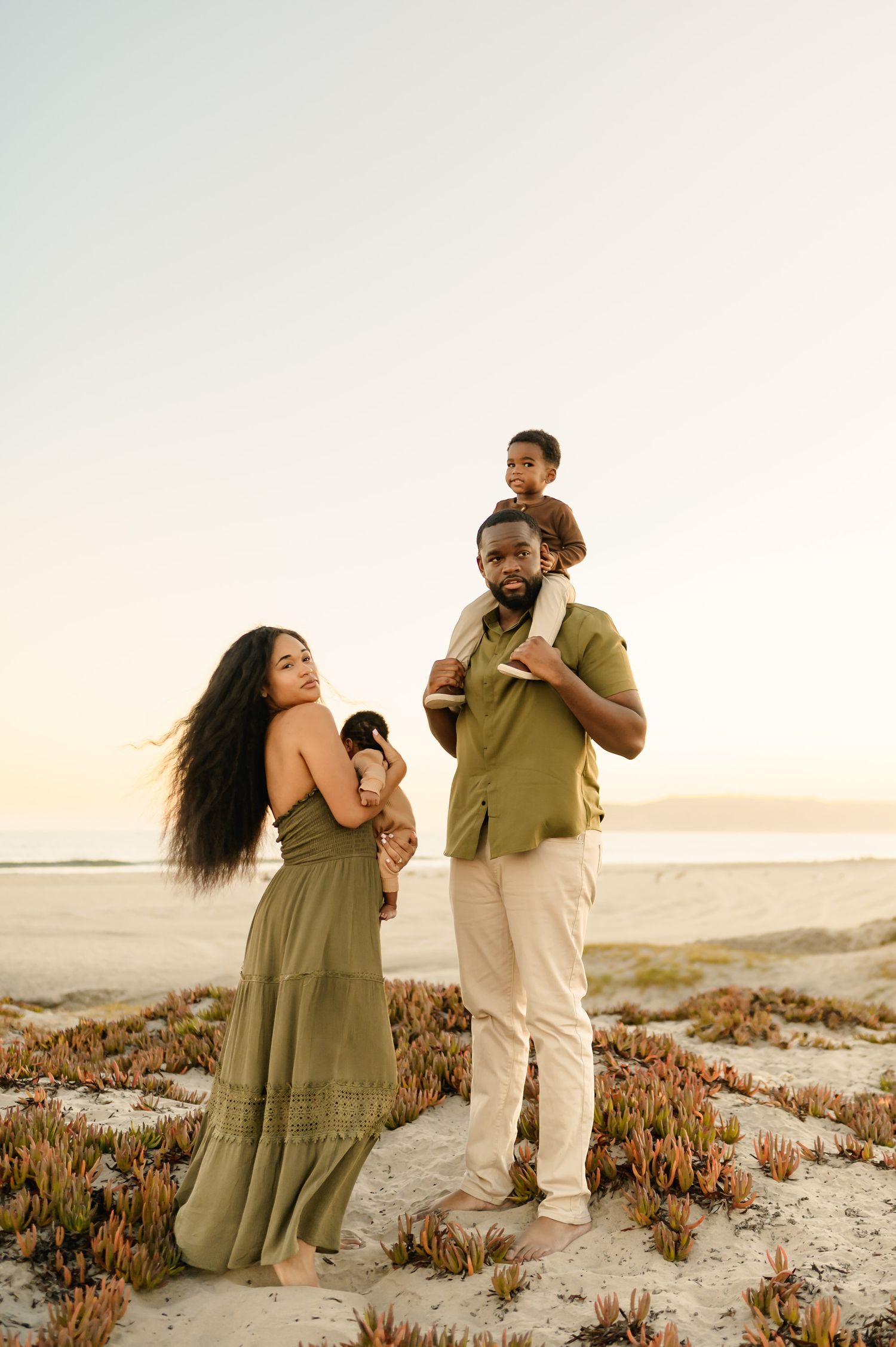 Golden hour beach family photoshoot by Santa Barbara photographer, of family with two kids playing on sand dunes at Ventura beach