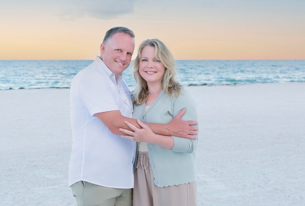 Pam and Shawn embracing on the beach at golden hour