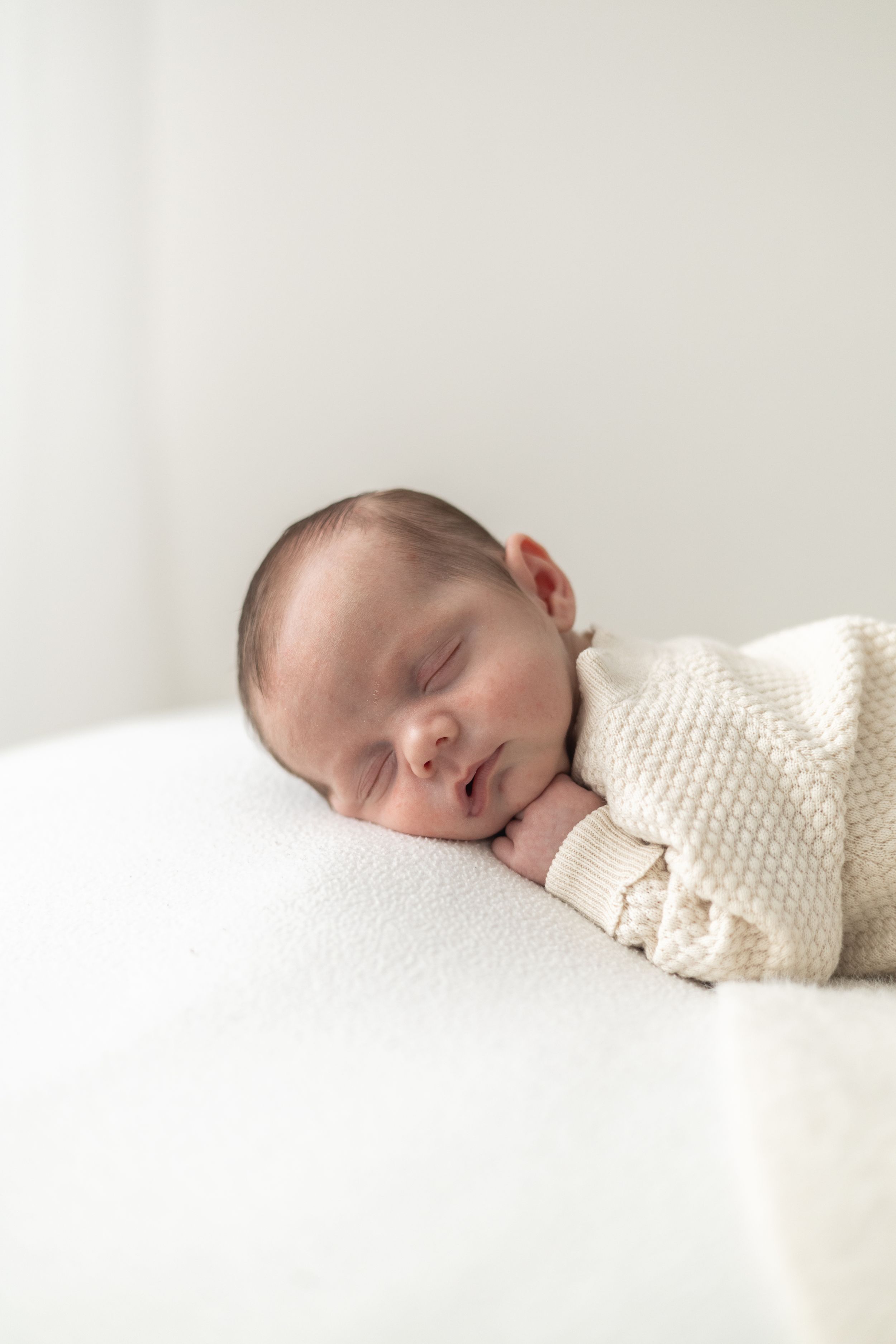 Natural newborn family photograph taken in a cosy Nottingham photography studio.