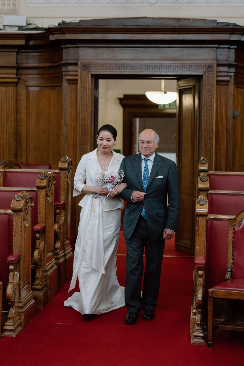 Bride walks down the aisle at Islington Town Hall.
