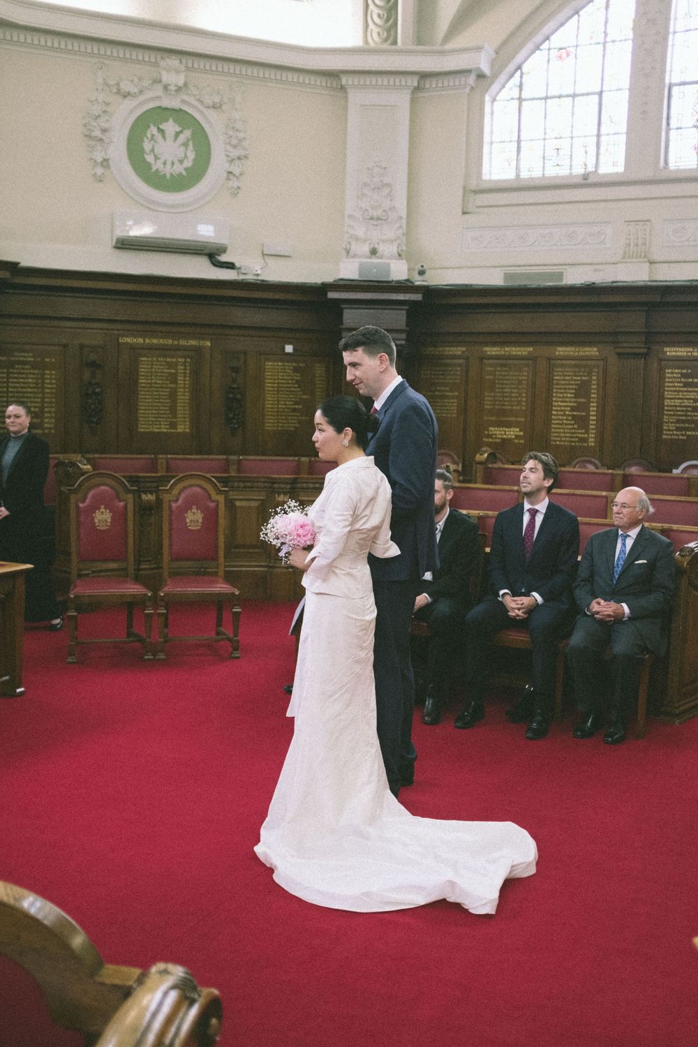 Bride and groom stand in Islington Town Hall.