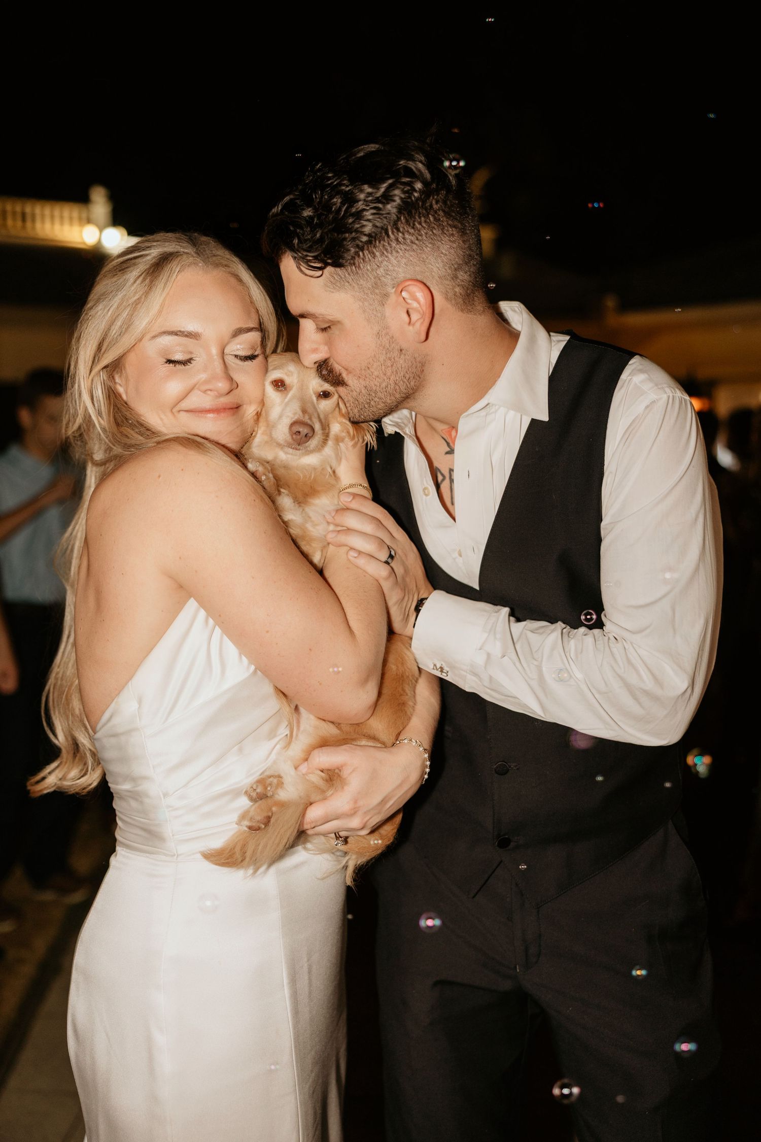 Bride and Groom kissing a dog during the grand exit at the wedding venue The Wildflower 301.