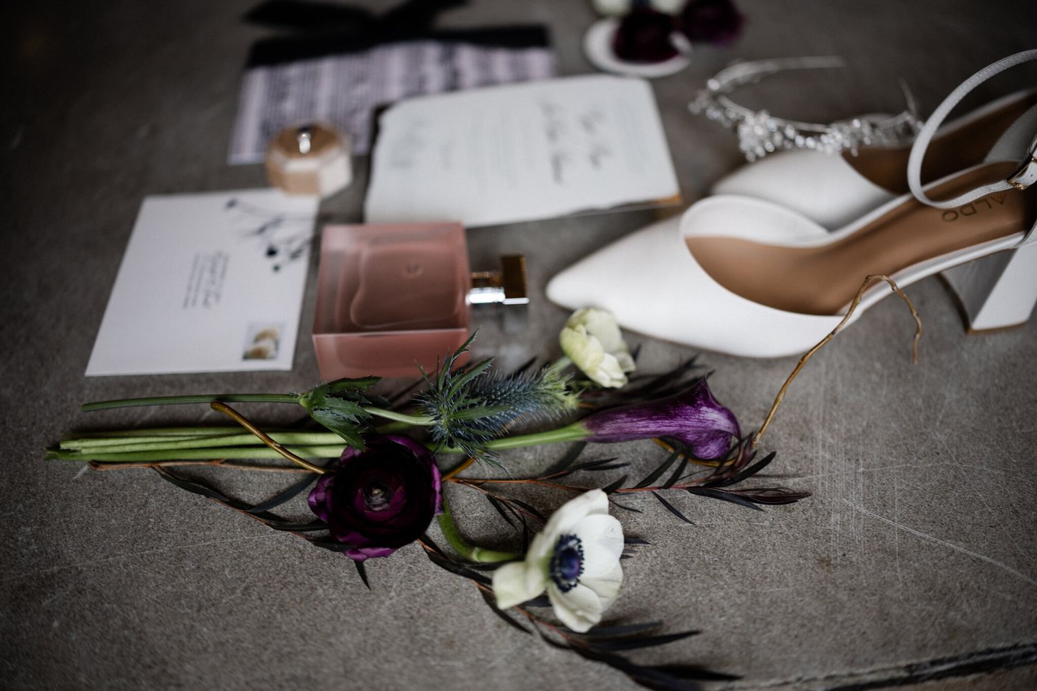 Bridal details with anemones, thistle, white heels, perfume and stationery at a Banff Springs Christmas wedding