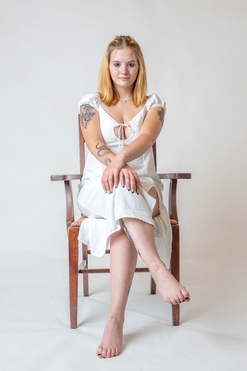 Studio personal branding portrait of a young woman seated against a neutral background