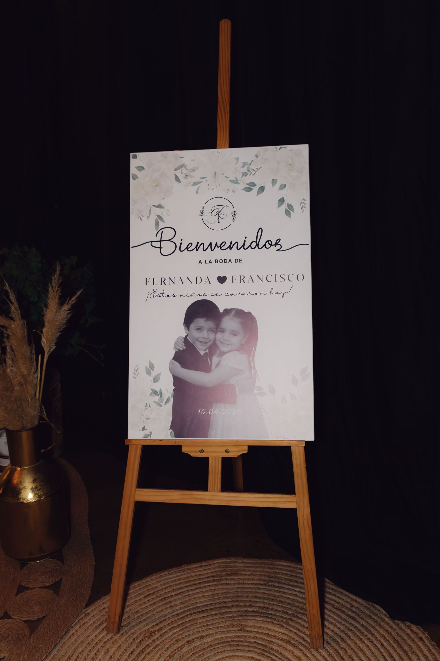 Wedding welcome sign reading Bienvenidos a la Boda de Fernanda y Francisco on wooden easel.