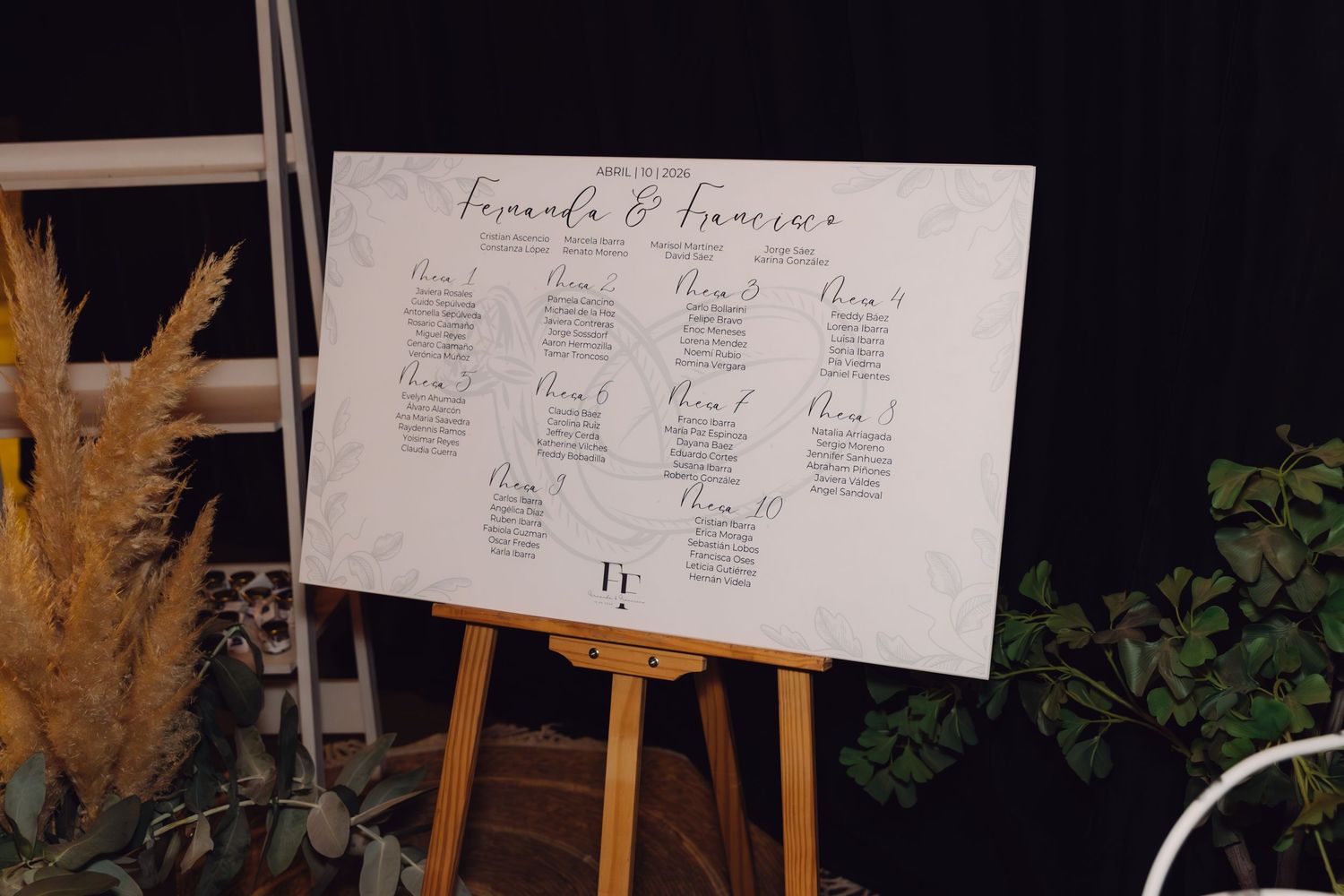 Fernanda and Francisco wedding seating chart displayed on white board mounted on wooden easel.