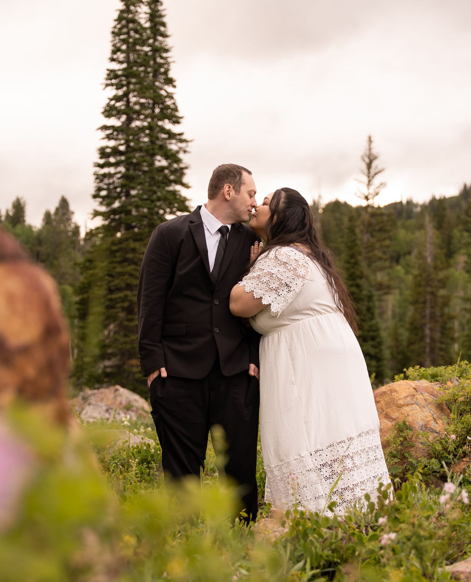 Couple embracing and kissing in logan canyon during their engagement session in Tony's grove.