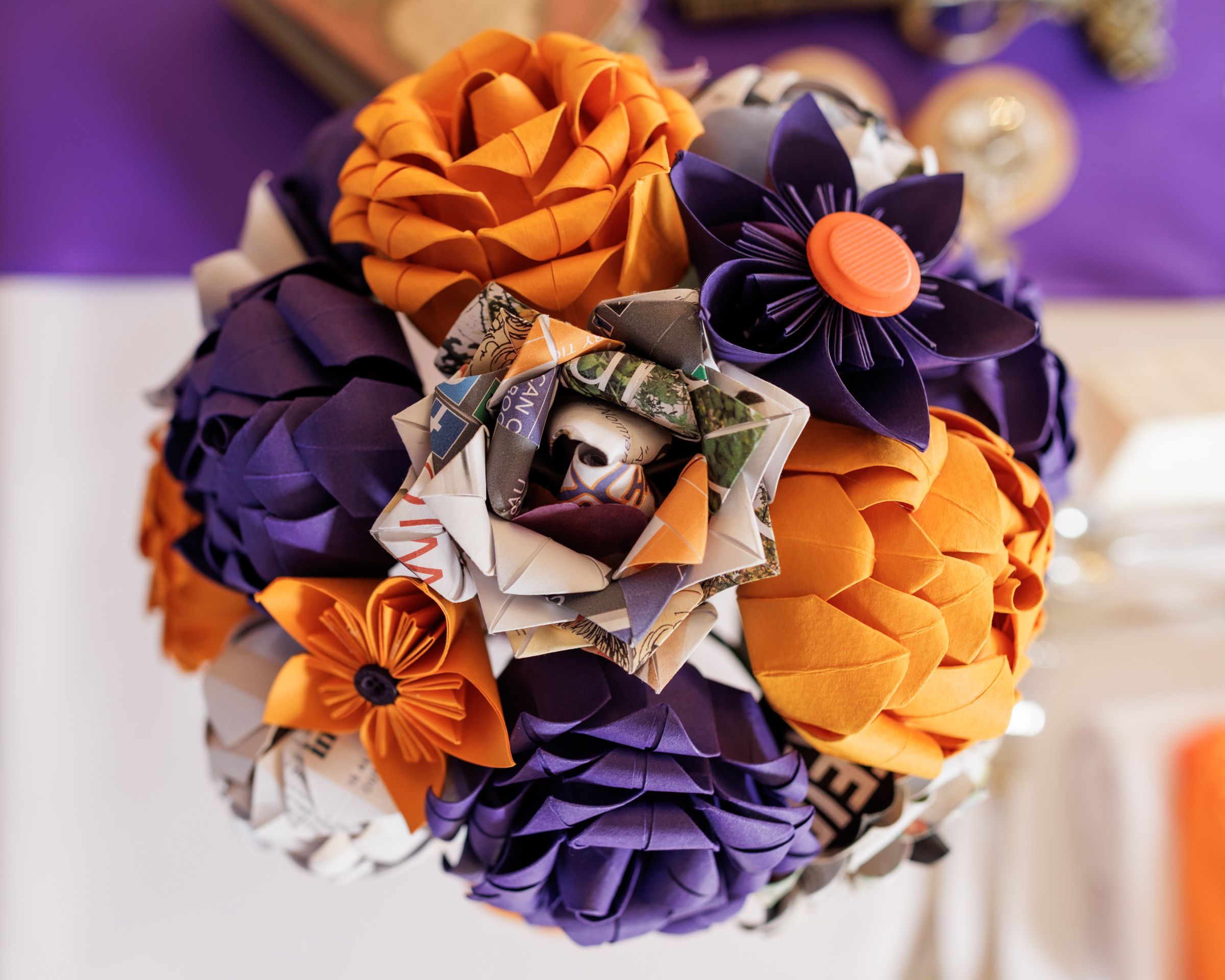 Handmade origami paper flower bouquet in orange and purple with money flower centerpiece.