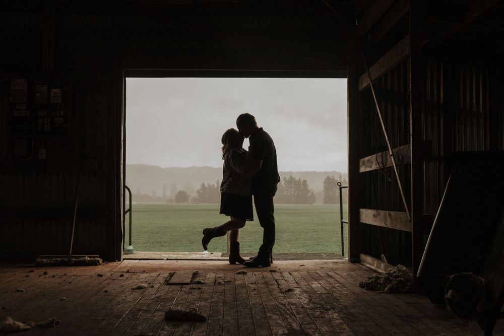engaged couple kissing in the wool shed on the family farm