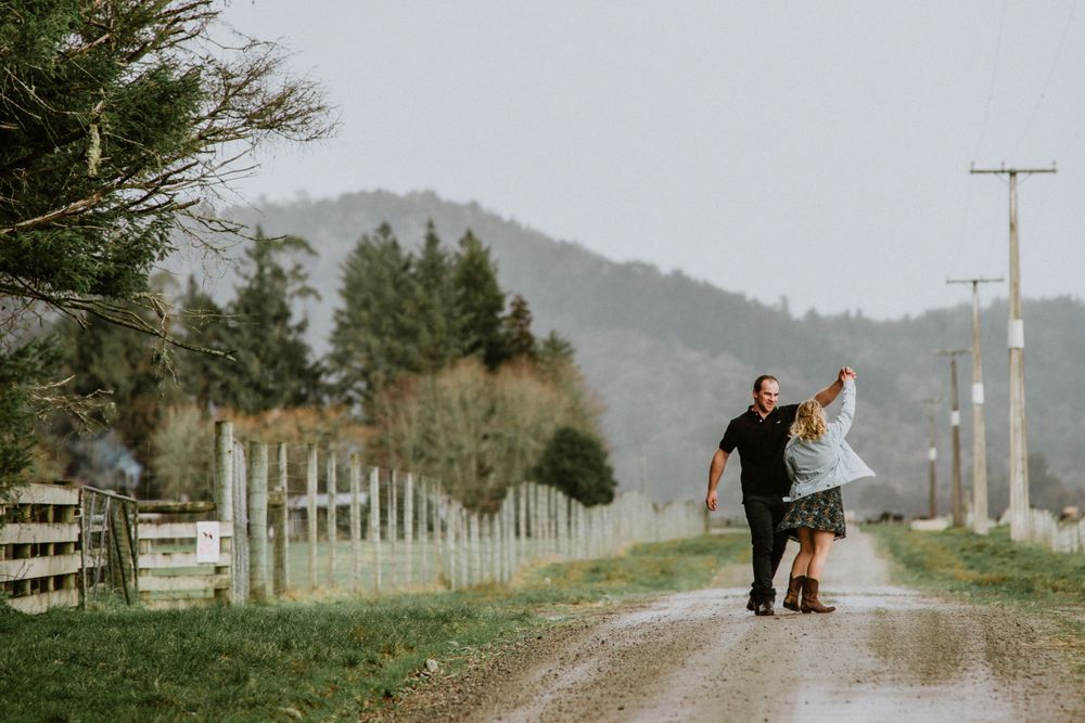 engaged couple dancing on the road on the family farm on the West coast of New Zealand