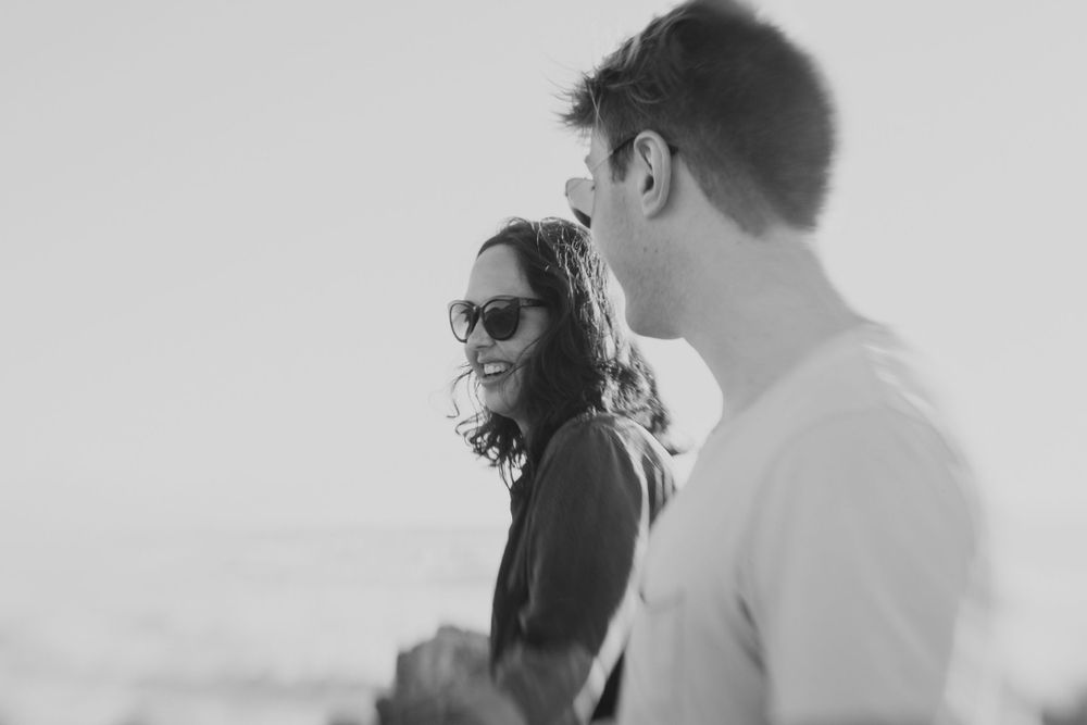 Black and white photo of couple walking laughing in Greymouth