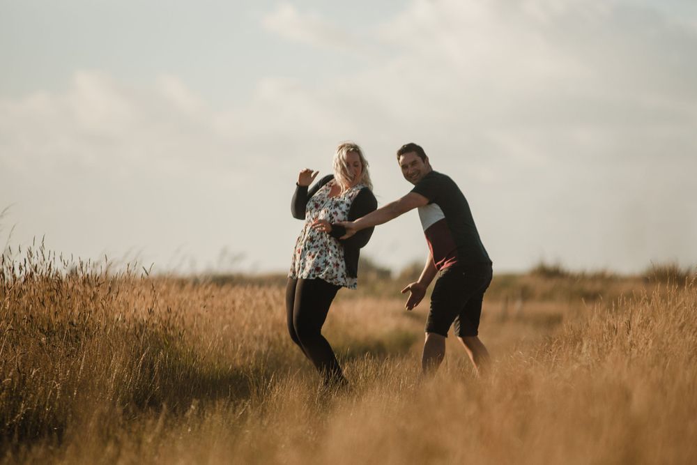 engaged couple laughing and dancing together in greymouth