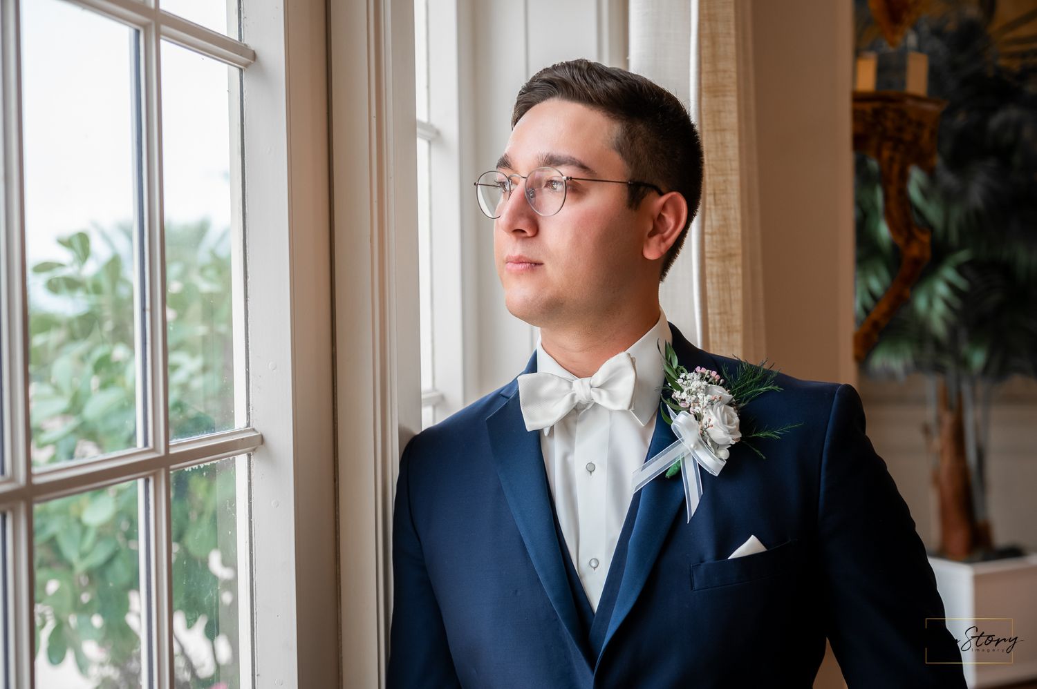Editorial wedding portrait near a large bay window of Whitehall in Palm Beach.