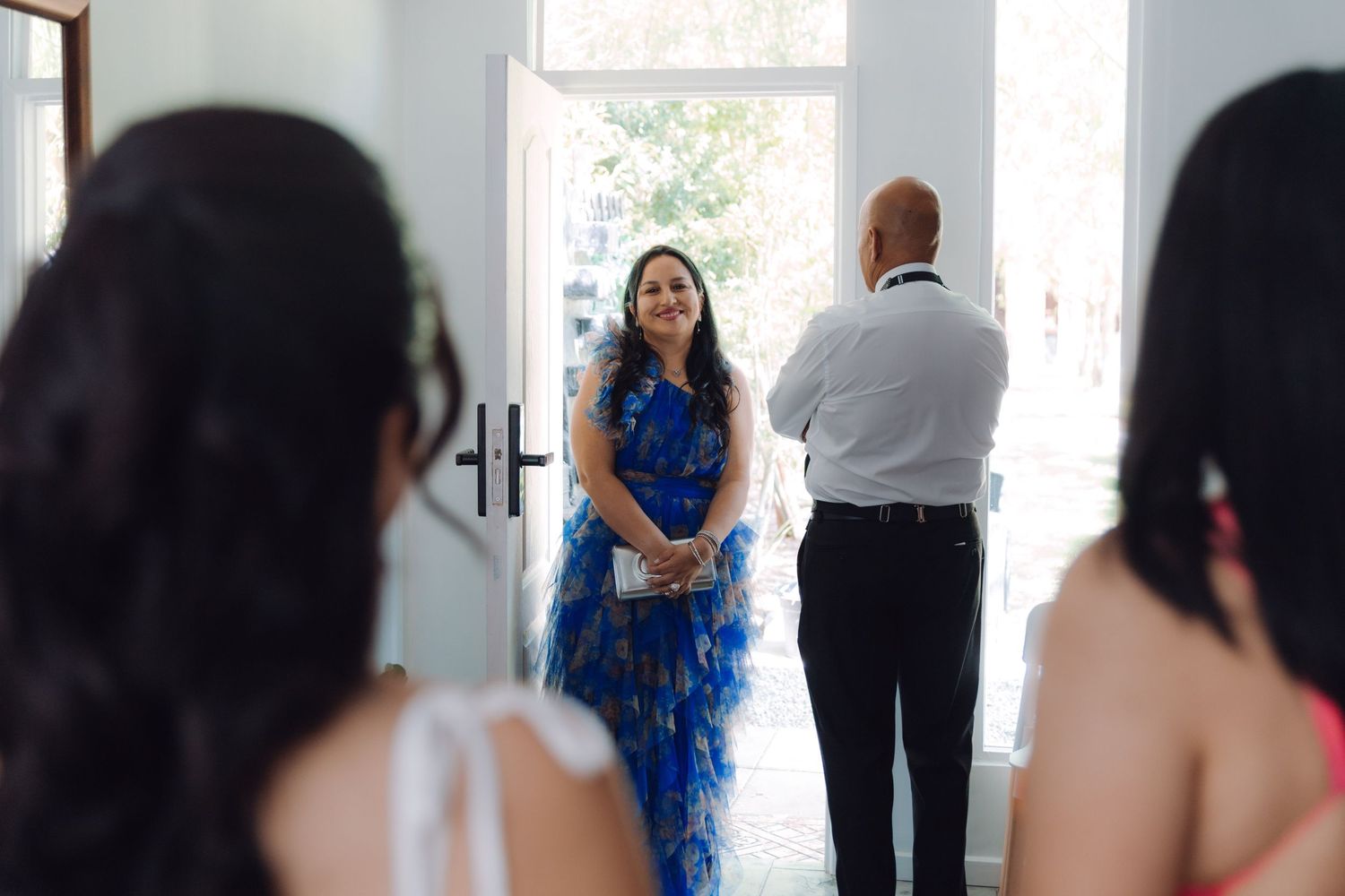 Emotional mother in blue floral dress and father react to seeing the bride before the ceremony.