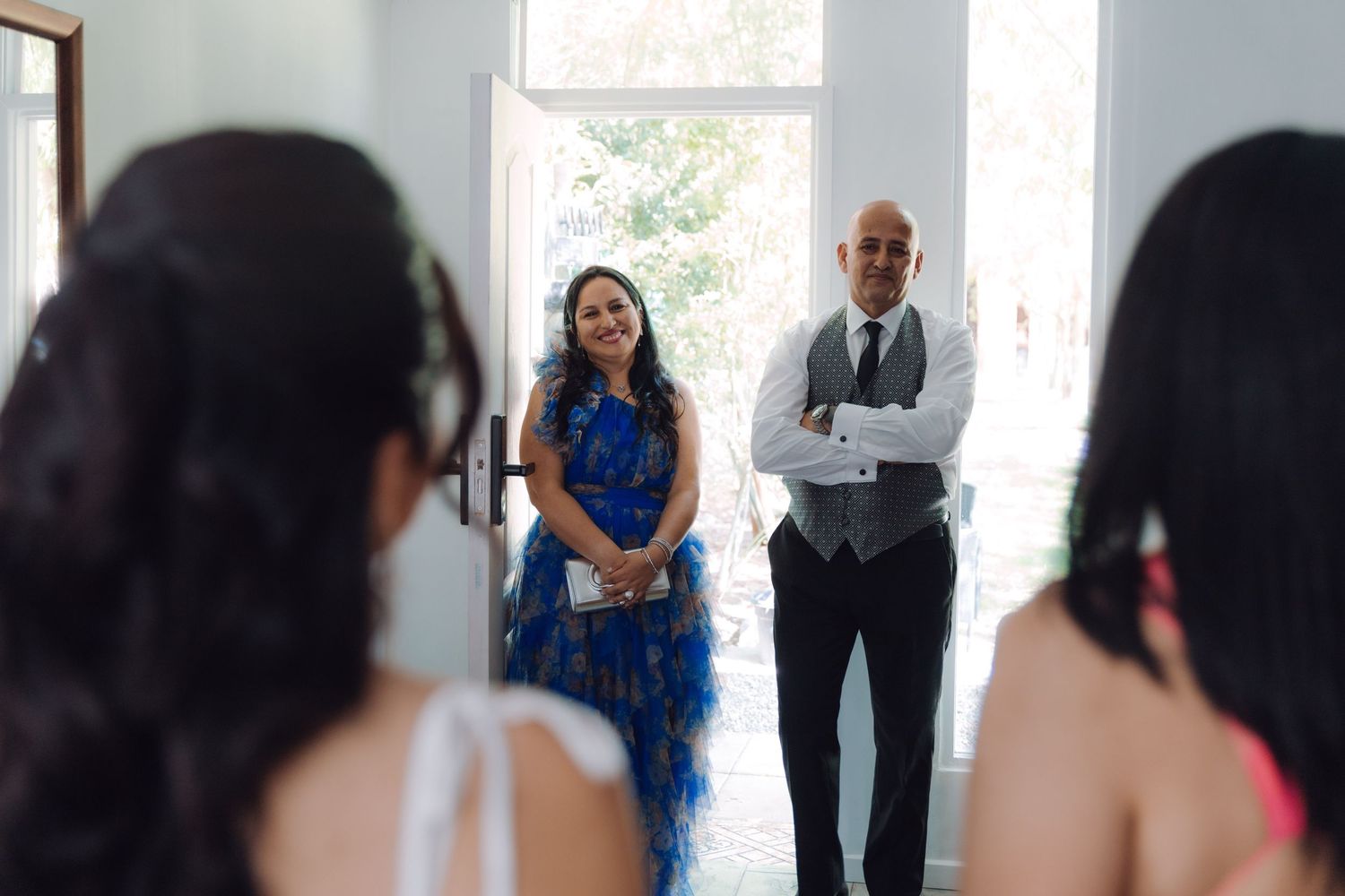 Parents smile proudly as they see their daughter the bride for the first time on her wedding day.