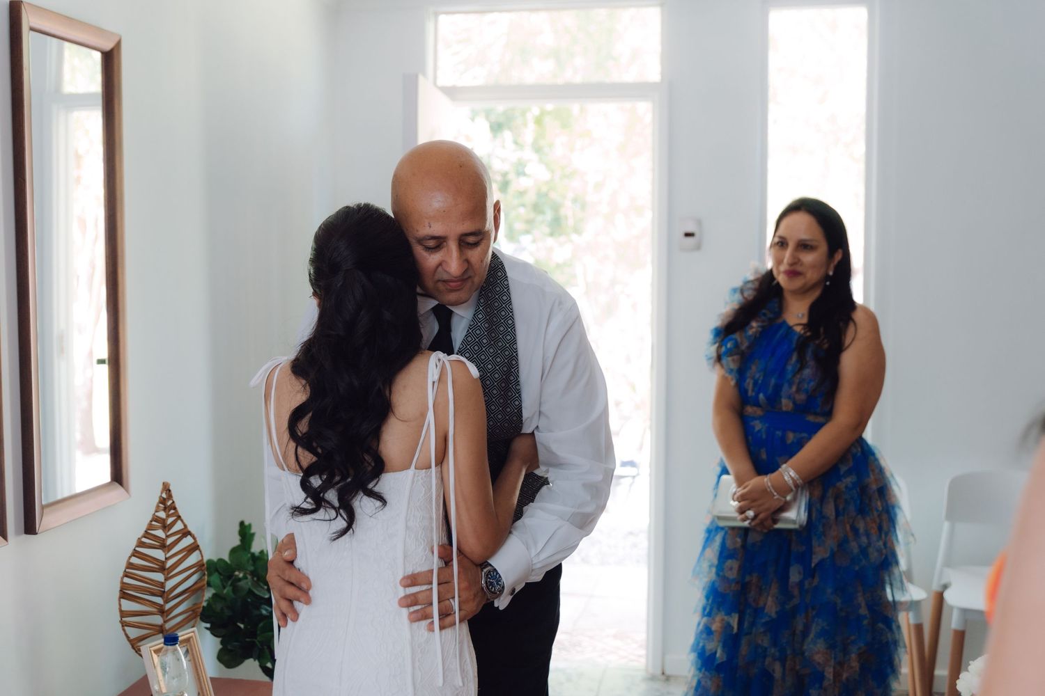 Father embraces his daughter the bride during an emotional first look moment on her wedding day.