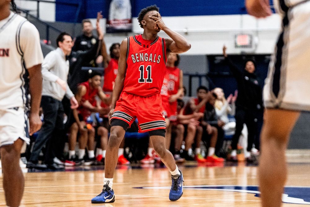 A Bengals player wearing number 11 reacts emotionally during a high school basketball game.