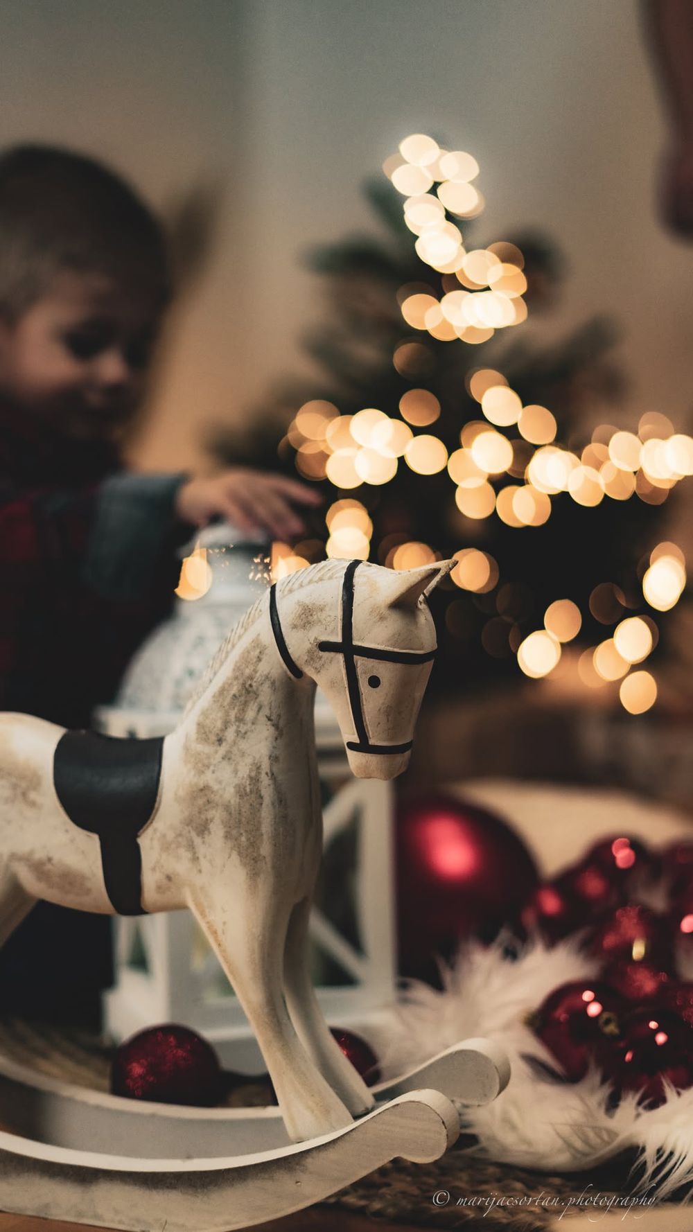 Bunt geschmückter Weihnachtsbaum mit funkelnden Lichterketten im Wohnzimmer.
