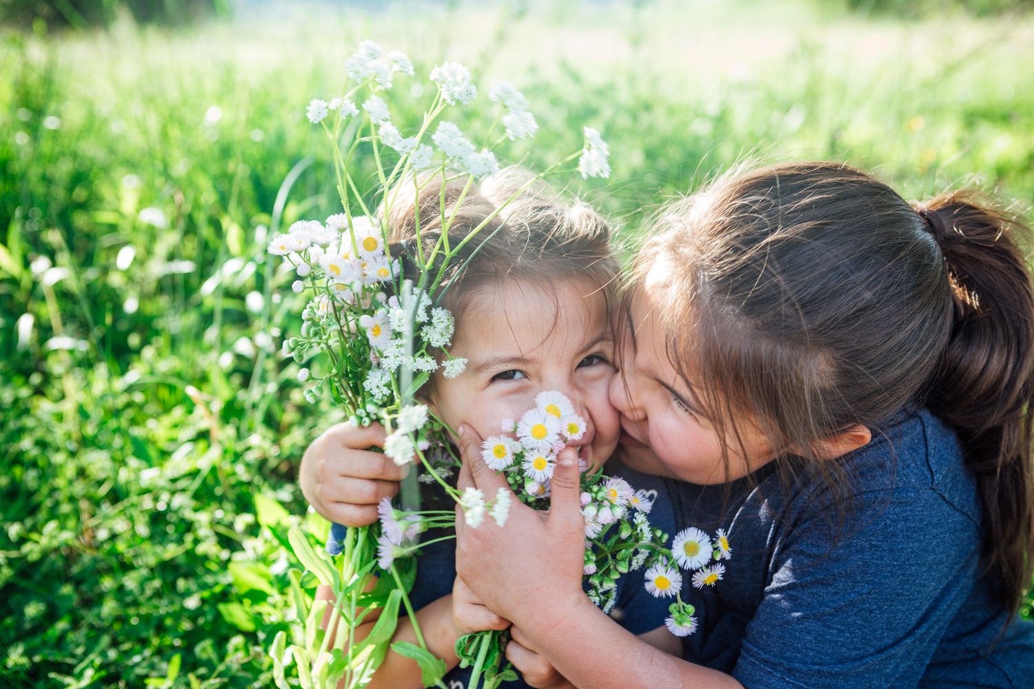 Candid family portrait moment with child handing sister a wildflower, Bryson City NC photographer