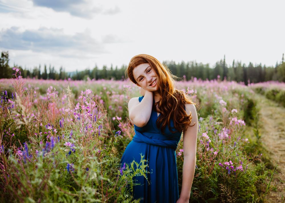 Teen standing in a field of wildflowers during an outdoor portrait session