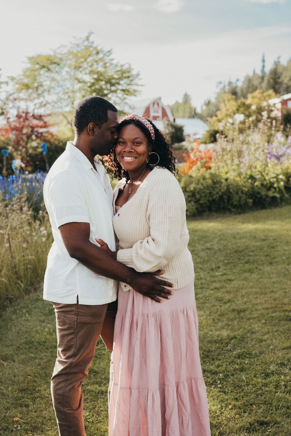 Couple embracing in a grassy field during an outdoor portrait session