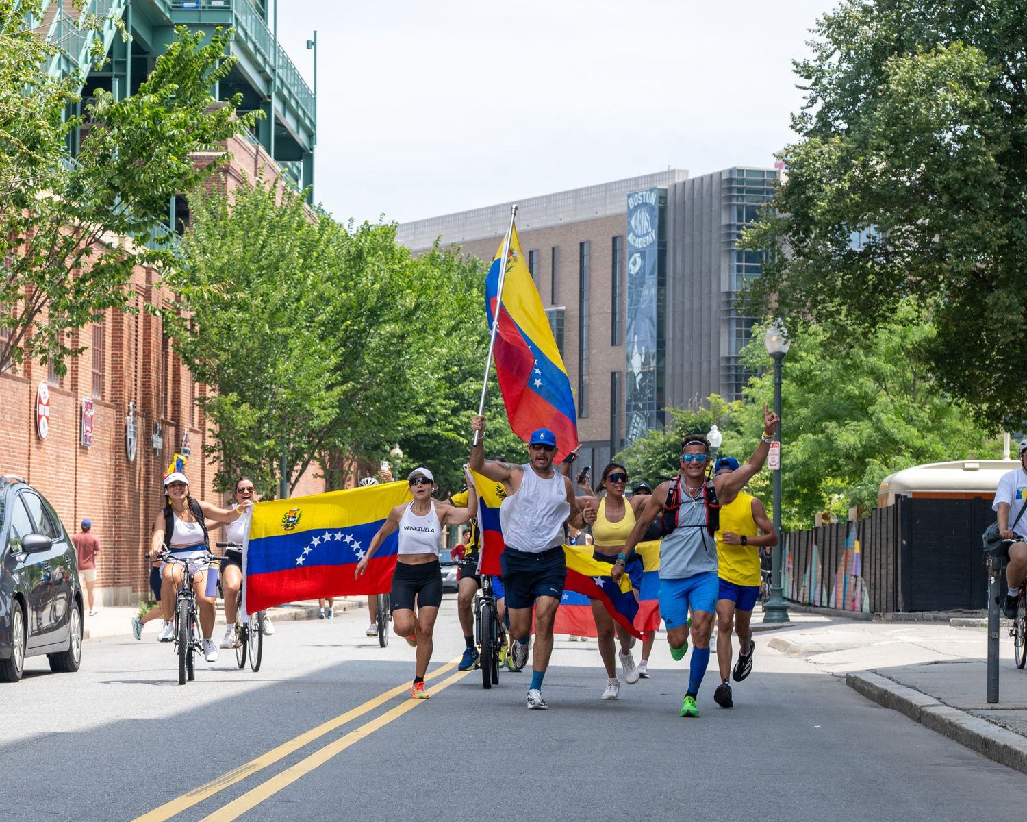 Runners carrying Venezuelan flags at fundraiser event for Venezuelan earthquake victims. They're empowered by their run