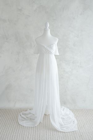 Robe blanche et vaporeuse en voilage laissant voir le ventre de la future maman dans la collection de la garde-robe studio de Judith Trudel