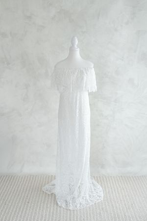 Robe de dentelle blanche épousant la silhouette de la future maman disponible dans la garde-robe du studio de photographie de Judith Trudel