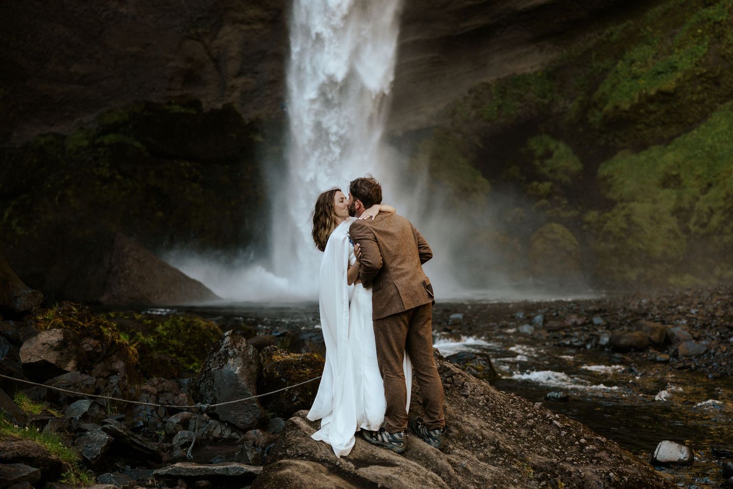 Couple kissing at the bottom of Kvernufoss waterfall during their Iceland Elopement day