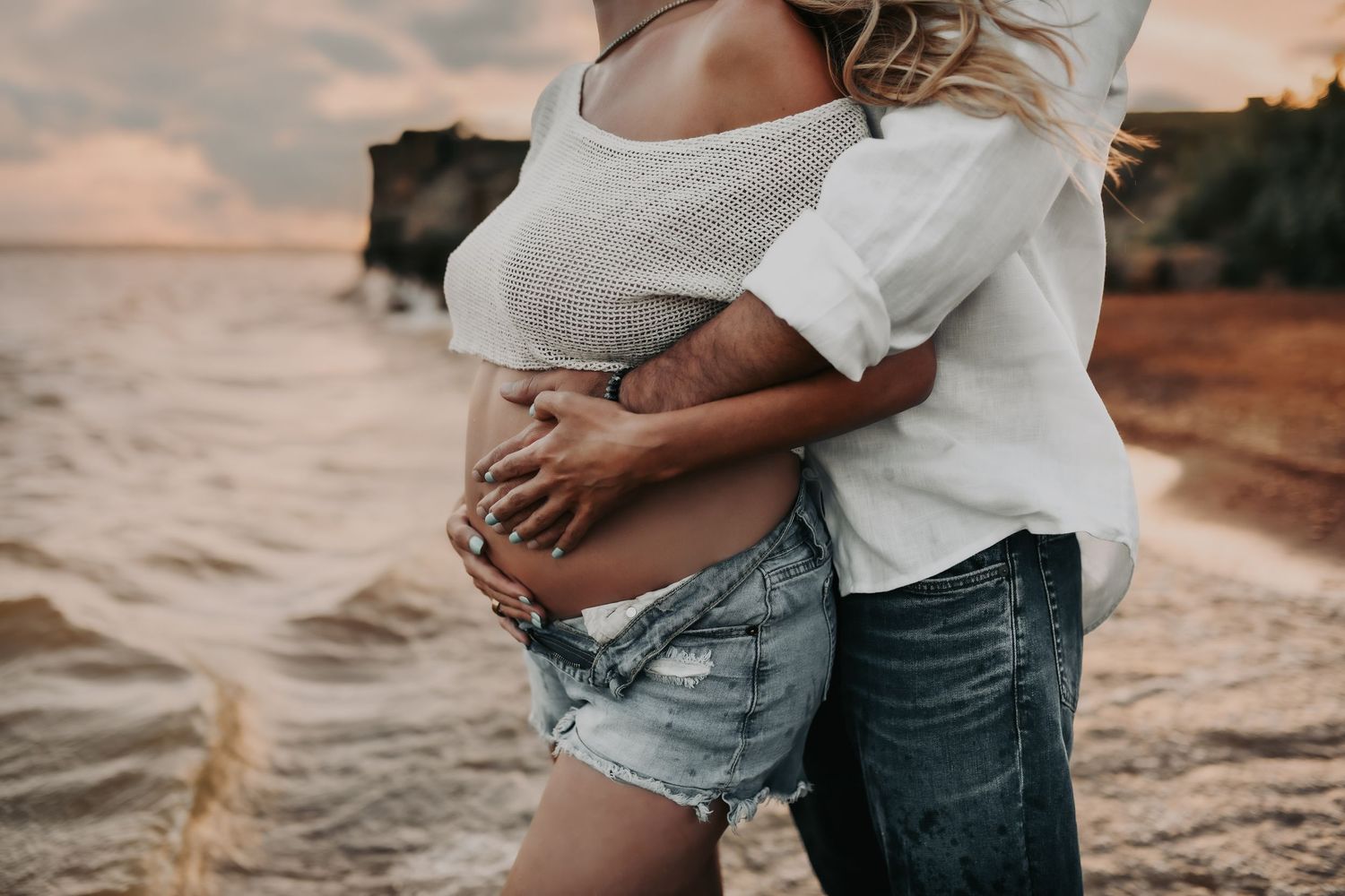Couple watching the sunset during their maternity session